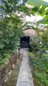 湖畔遊 部屋へ向かう小道｜自然豊かな緑に囲まれたアプローチ：Pathway to the guest suite at Kohanyu, surrounded by lush greenery